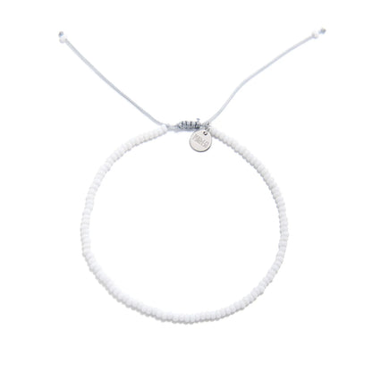 Small Beaded Bracelets shown from above with white seed beads with gray cord and round bracelet shape