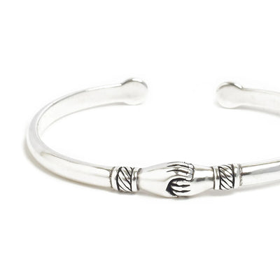 Close-up of Stainless Steel Bracelets cuff showing handshake centerpiece and carved line details