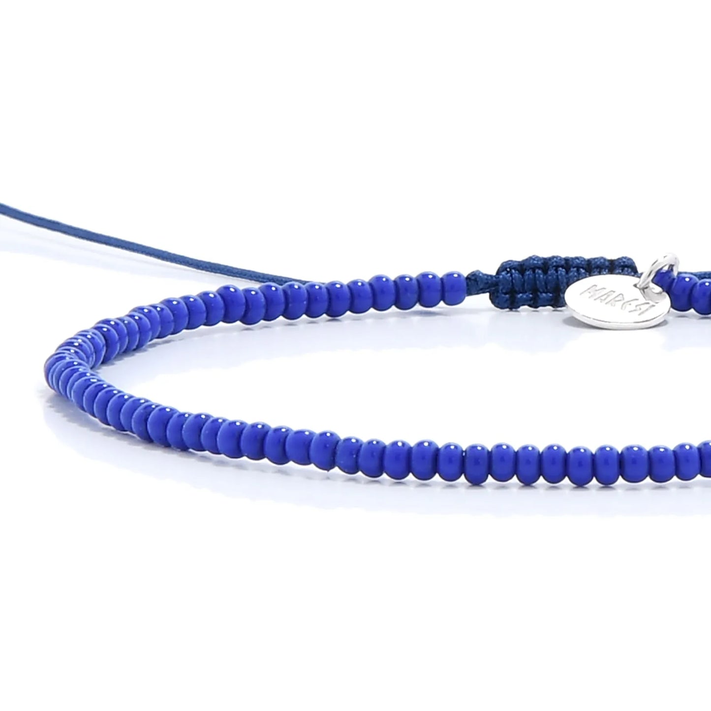 Close-up of Stretch Bead Bracelets showing blue seed beads with black cord, silver charm, and cord closure