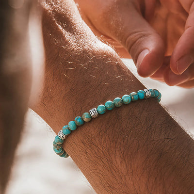 Turquoise Jewelry worn on a wrist with beaded design and adjustable cord