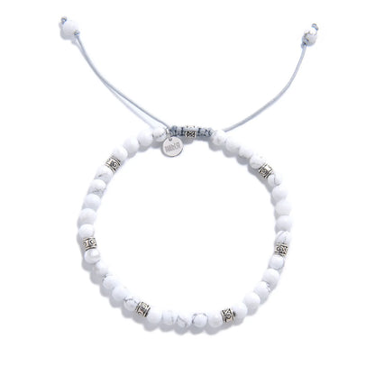 White Howlite Bracelet top view with round beads, charm, and adjustable cord