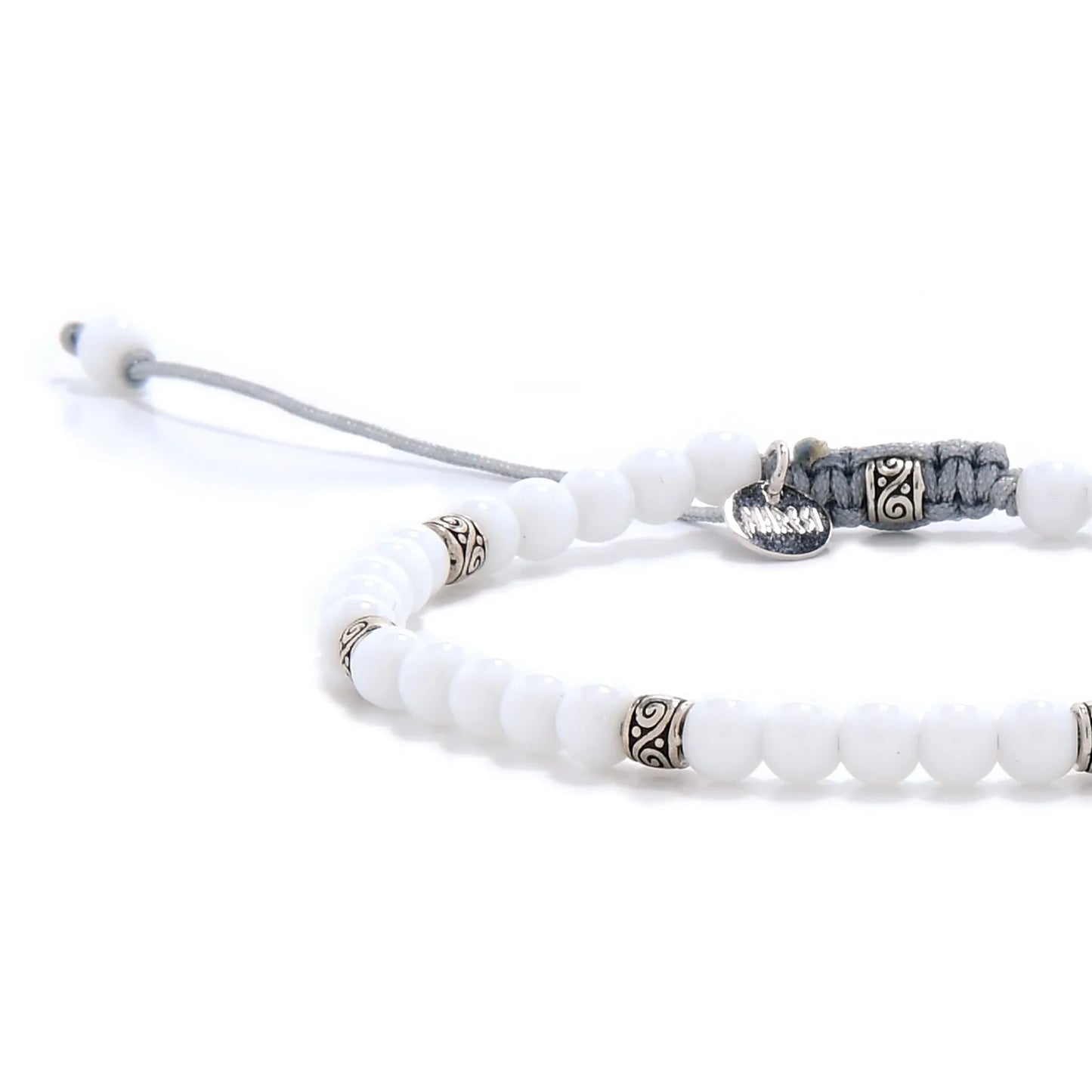 Close-up of White Jade Bracelet beads with silver spacers, gray cord, and polished white stones.