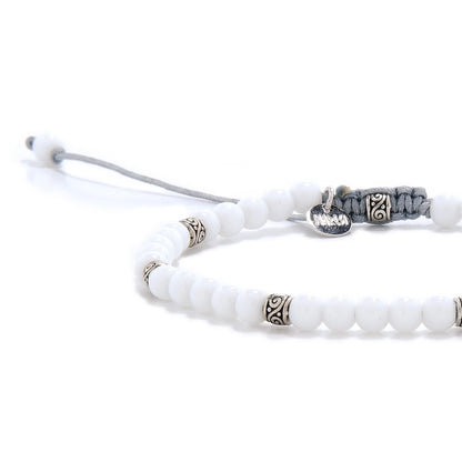 Close-up of White Jade Bracelet beads with silver spacers, gray cord, and polished white stones.