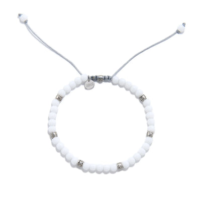 Top view of White Jade Bracelet with round white beads, silver spacers, gray cord, and charm.