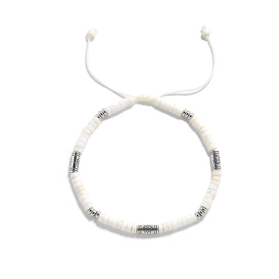 White Stone Jewelry shown from above with white clay beads with engraved silver spacers and round bracelet shape
