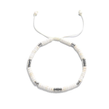 White Stone Jewelry shown from above with white clay beads with engraved silver spacers and round bracelet shape