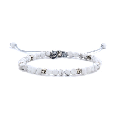 White howlite bead bracelet displayed on a white background, featuring silver accents and a braided adjustable cord.
