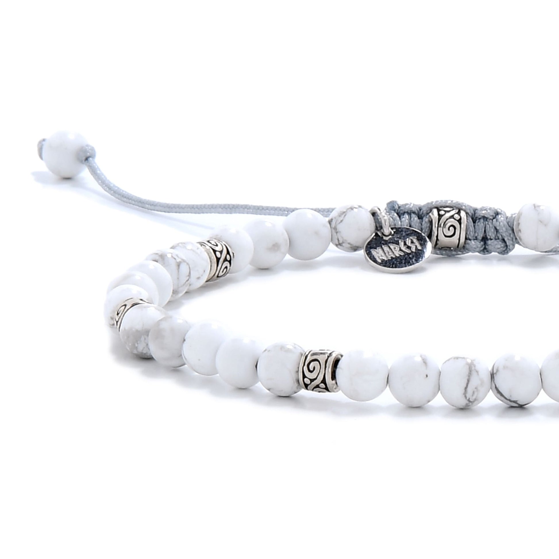 White howlite bracelet close-up highlighting the smooth, marbled beads and intricate silver spacers for texture and contrast.
