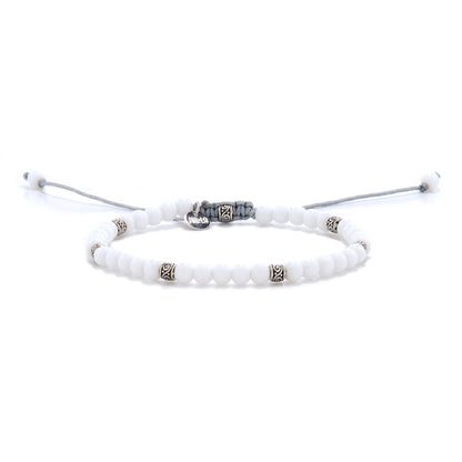 Minimalist white jade bracelet with silver-toned spacers and adjustable gray cord, displayed on a white background.
