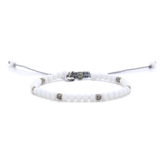 Minimalist white jade bracelet with silver-toned spacers and adjustable gray cord, displayed on a white background.