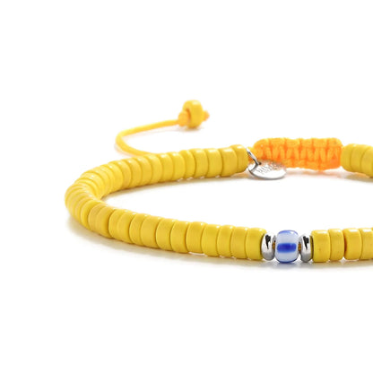 Close-up of Yellow Beads showing yellow clay beads with blue accent bead, silver charm, and cord closure