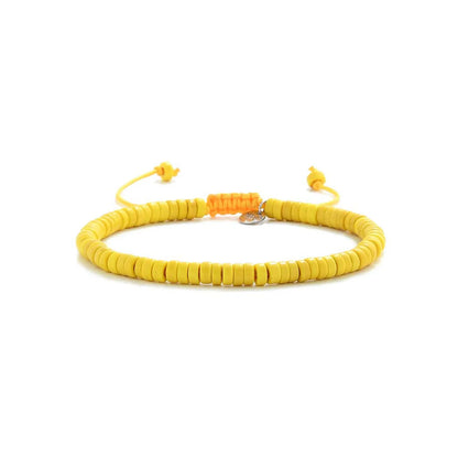 Yellow Bracelet shown in full view with yellow clay beads with silver charm and adjustable cord