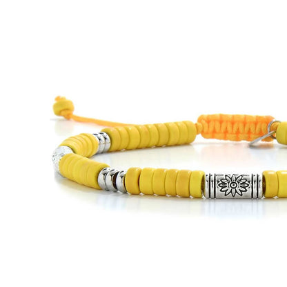 Close-up of Yellow Gemstone Jewelry showing yellow clay beads with engraved silver spacers, silver charm, and cord closure