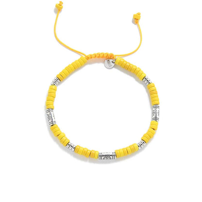 Yellow Gemstone Jewelry shown from above with yellow clay beads with engraved silver spacers and round bracelet shape