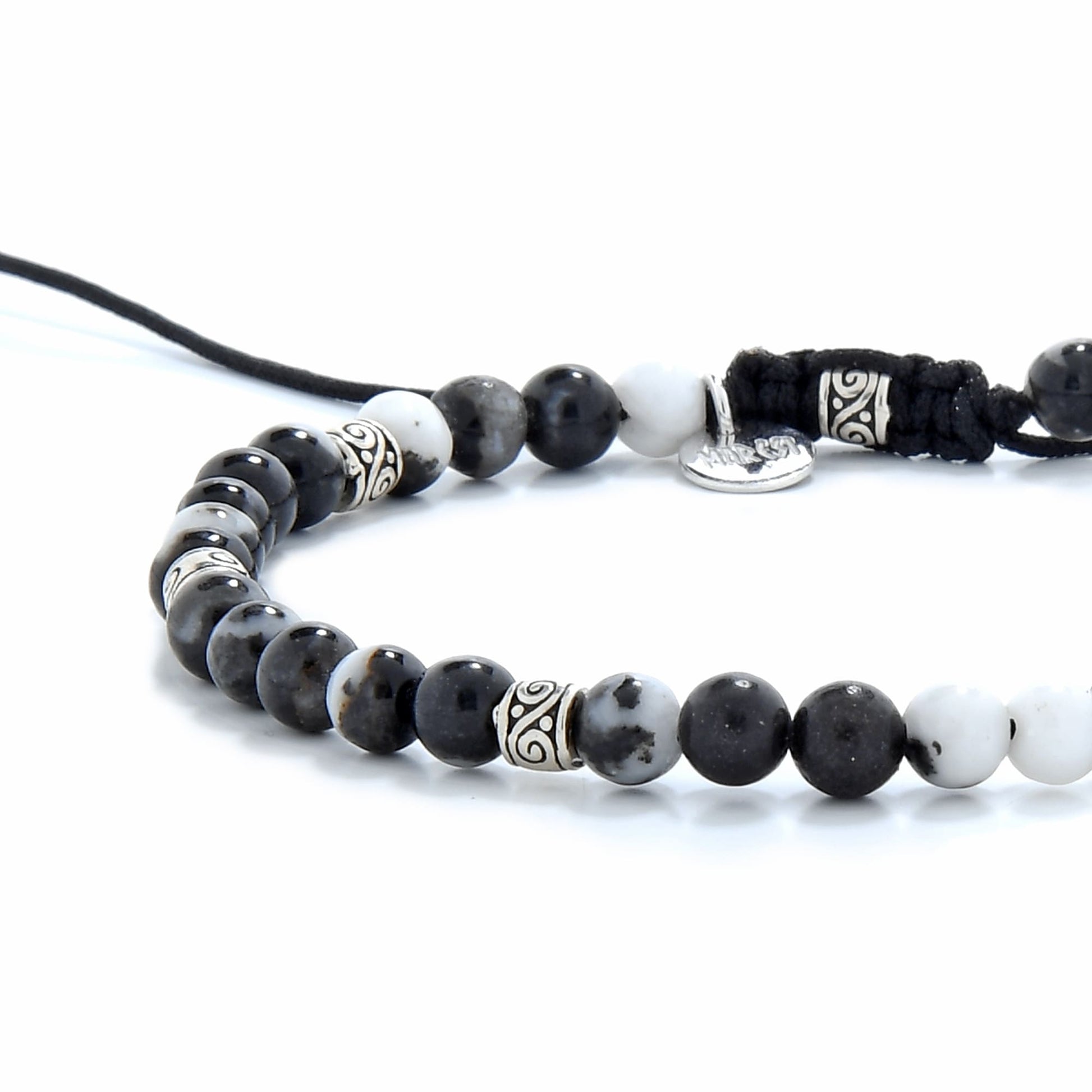 Zebra jasper bracelet displayed on white background, featuring polished black and white gemstone beads and silver detailing
